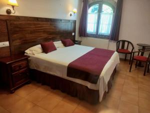 ein Schlafzimmer mit einem großen Bett mit hölzernem Kopfteil in der Unterkunft Hotel Trapa in Soto de Cangas