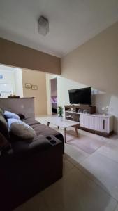 a living room with a couch and a flat screen tv at Casa temporada Martins,RN in Martins