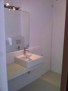 a white bathroom with a sink and a mirror at Casa immersa nel verde a pochi passi dalla playa in Illes Balears