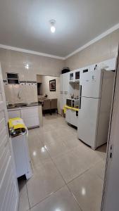 a kitchen with white appliances and a large room at Casa temporada Martins,RN in Martins