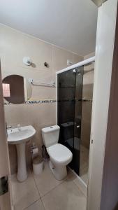 a bathroom with a toilet and a sink at Casa temporada Martins,RN in Martins