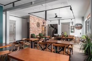 a restaurant with tables and chairs and a brick wall at Vasara in Rušenīca