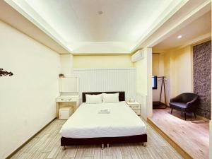 ein Schlafzimmer mit einem Bett und einem Stuhl darin in der Unterkunft 幸福滿屋民宿-包棟詢問 in Hualien