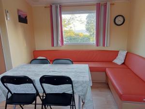 a room with a red couch and chairs and a table at Ferme de ussau in Betchat