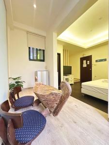 a room with two chairs and a table and a bed at 幸福滿屋民宿-包棟詢問 in Hualien City