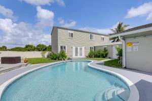 a swimming pool in front of a house at 6 Mi to Riviera Beach WPB Retreat with Pool Access! in West Palm Beach