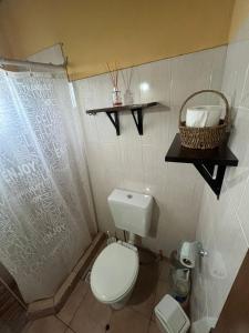 a bathroom with a toilet and a basket of towels at El Descanso Deseado in Puerto Deseado +22 photos