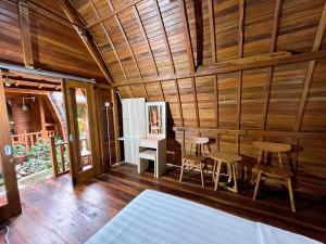 a room with wooden walls and a table and chairs at De Ravin Bungalows Canggu in Dalung