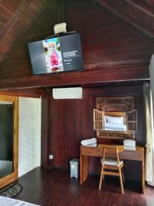 a room with a desk and a tv on the ceiling at Uma Desa - Surf And Stay Medewi in Airsatang