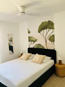 ein Schlafzimmer mit einem Bett und einem Gemälde an der Wand in der Unterkunft Appartement T2 chambre plus cabine, terrasse vue piscine in Bormes-les-Mimosas