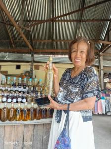 琅勃拉邦3 days tour to visit surroundings of Luang Prabang的一名女子举着一瓶酒