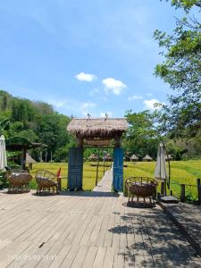 琅勃拉邦3 days tour to visit surroundings of Luang Prabang的公园内一个带椅子和遮阳伞的凉亭