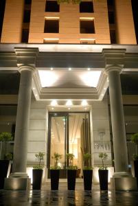 a building with columns and potted plants in front of it at Premium Tower Suites Mendoza in Mendoza