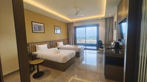 a hotel room with two beds and a balcony at Pride Resort Jodhpur in Banār
