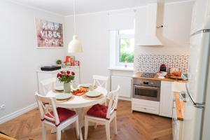 a white kitchen with a white table and chairs at Best Place#2 in Jõhvi