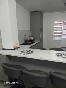a kitchen with a counter with chairs around it at Isabell Apartaments in Râmnicu Vâlcea