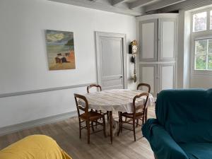 a living room with a table and chairs and a couch at Gitevdelacour in Sainte-Même