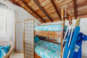two bunk beds in a room with wooden ceilings at Mermaid Cottage in Falmouth