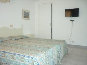 sypialnia z łóżkiem i telewizorem na ścianie w obiekcie Apartamentos Jorbar w El Arenal