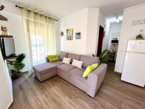 Una sala de estar con un sofá y un televisor. en Casa da Praia na Torre Castelo, en Armação de Pêra