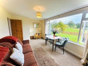 a living room with a couch and a table and a window at 1 Bed in Hawkshead Village LLH16 in Hawkshead