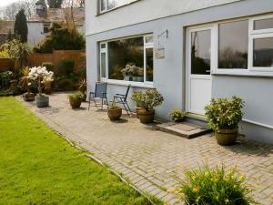 a patio with chairs and plants in front of a house at 1 Bed in Hawkshead Village LLH16 in Hawkshead