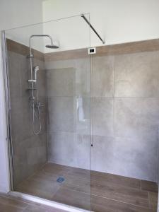 a shower with a glass door in a bathroom at B&B La Foglietta in Paganica