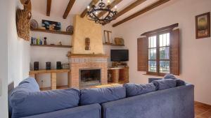 a blue couch in a living room with a fireplace at Cada Adrian Almachar by Ruralidays in Almáchar
