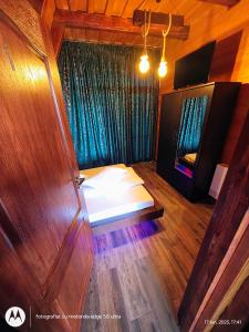 a bedroom with a bed and a wooden door at Casuta din LAZ in Onceşti