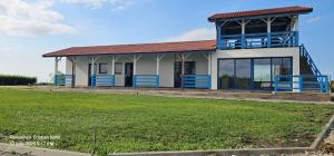 a house with a large lawn in front of it at Cameră de inchiriat și Camping La Agop in Murighiol
