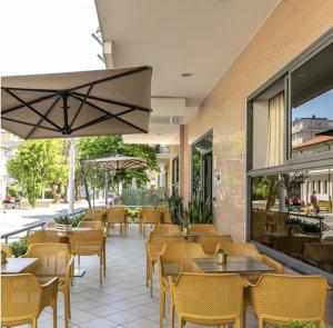 a restaurant with tables and chairs and a patio at Hotel Atlantic in Bellaria-Igea Marina