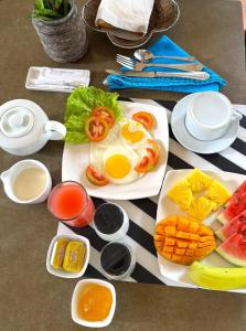 a table with a plate of eggs and fruits and vegetables at Ali Bungalow - Galle in Galle