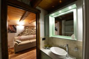 Un baño con lavabo, espejo y cama. en Avenue des Thermes, en Pré-Saint-Didier