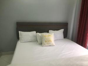 a bed with a pillow that says home only hour at Bright Serene Studio Bnb in Nairobi