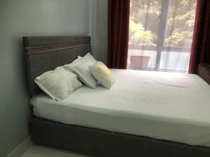 a bed with two pillows on it with a window at Bright Serene Studio Bnb in Nairobi