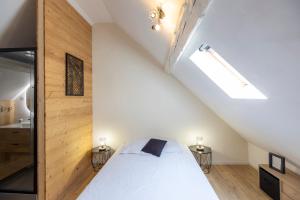 Schlafzimmer mit einem weißen Bett und Holzwänden in der Unterkunft T2 Cosy idéalement situé in Briançon