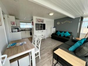 un soggiorno con un divano e un tavolo di Beach Cottage 44, Just Minutes Walk From The Sea a Westward Ho Altre 20 foto