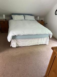a bedroom with a bed with white sheets and pillows at Hillhouse in Hythe