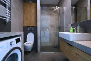 une salle de bain avec toilettes et lavabo et une machine à laver dans l'établissement Apartament #CapitalTower 167 FV PARKING, à Rzeszów