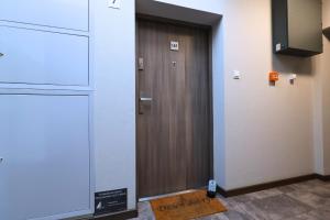 - une porte en bois dans une chambre avec un panneau au sol dans l'établissement Apartament #CapitalTower 167 FV PARKING, à Rzeszów