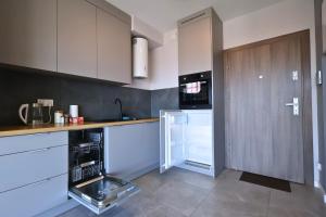 La cuisine est équipée de placards blancs et d'un réfrigérateur ouvert. dans l'établissement Apartament #CapitalTower 167 FV PARKING, à Rzeszów 4 autres photos