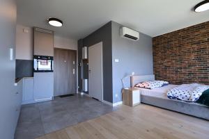 une chambre avec un lit et un mur de briques dans l'établissement Apartament #CapitalTower 167 FV PARKING, à Rzeszów