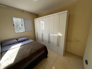 a bedroom with a bed and a large white cabinet at Apartamento WJM in Espirito Santo Do Pinhal
