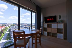 une salle à manger avec une table et des chaises et une grande fenêtre dans l'établissement Apartament #CapitalTower 167 FV PARKING, à Rzeszów