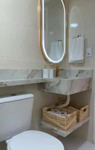 a bathroom with a white toilet and a mirror at Apart Atalaia ar cond 2 qtos in Aracaju +29 photos
