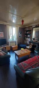 a living room with couches and a coffee table at Maison de ville in Rouen