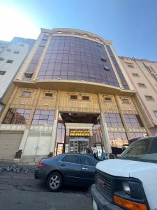 a blue car parked in front of a building at فندق جوهرة ميسر in Quai