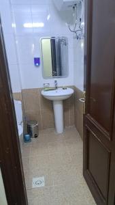 a bathroom with a sink and a mirror at فندق جوهرة ميسر in Quai