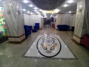 a corridor of a room with blue chairs and a table at فندق جوهرة ميسر in Quai