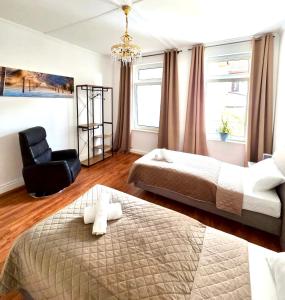 a hotel room with two beds and a chair at Ferienwohnung Fleiger 2 in Achim Zentrum in Achim